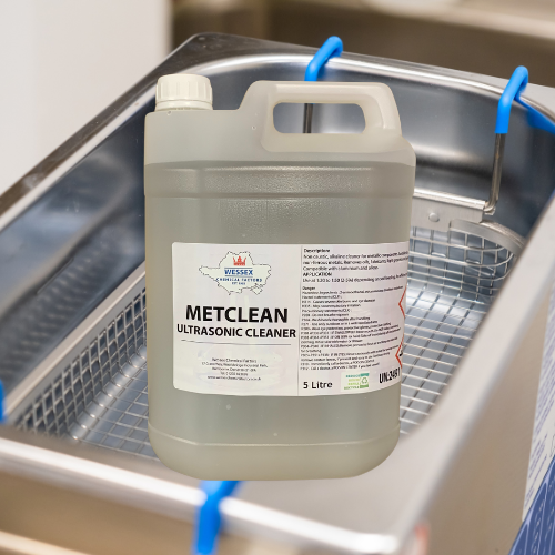 bottle of metclean ultrasonic cleaner in front of an ultrasonic bath