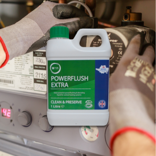 small bottle of powerflush extra in front of a boiler