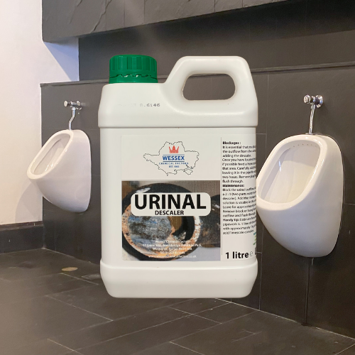 bottle of urinal descaler in front of row of urinals
