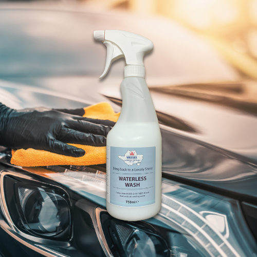 Bottle of waterless wash in front of a shiny car